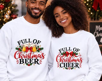 Puede incluir: Dos sudaderas blancas de cuello redondo con gráficos navideños. La sudadera de la izquierda muestra dos jarras de cerveza con el texto "FULL OF Christmas BEER". La de la derecha presenta un lazo rojo con el texto "FULL OF Christmas CHEER".