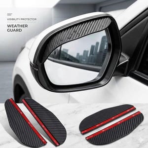 May include: Black carbon fiber car side mirror rain guards. The image shows the guards installed on a white car mirror and several detached guards with red adhesive strips. Text on the image reads "VISIBILITY PROTECTOR" and "WEATHER GUARD."