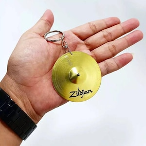 May include: A white ceramic mug with a black handle and the text "But First, Coffee" in a black, bold font. The mug is on a white surface.