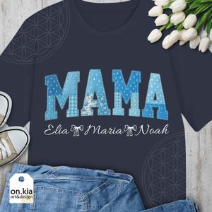 Könnte beinhalten: Marineblaues T-Shirt mit dem Wort "MAMA" in blau geflickten Buchstaben. Darunter stehen die Namen "Elia Maria Noah" in weißer Schrift. Das Shirt hat auch ein Logo mit der Aufschrift "on.kia art&design".