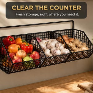 Könnte beinhalten: Ein schwarzes Wandregal aus Metall mit drei Drahtkörben für frische Lebensmittel. Über dem Regal steht der Text CLEAR THE COUNTER und Fresh storage, right where you need it. Die Körbe enthalten Paprika, Zwiebeln, Knoblauch und Ingwer.