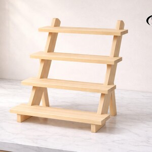 Puede incluir: Una estantería de madera de tres niveles de color claro. Los estantes están soportados por patas anguladas, creando un diseño escalonado. La parte superior de la estantería tiene un logotipo que dice "SmartSpace Organizer".