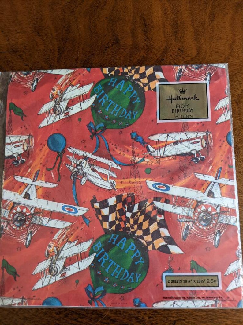 Pu&ograve; includere: Carta da regalo vintage Hallmark con sfondo rosso e un motivo ripetuto di aerei, palloncini e bandiere a scacchi. La carta dice "Happy Birthday" in un palloncino verde e "Boy Birthday" in un rettangolo dorato. La carta &egrave; composta da 2 fogli, 20 1/4" x 28 1/2" e costa 25 centesimi.