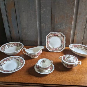 May include: A set of vintage floral patterned china dishes, including a small bowl, a large bowl, a gravy boat, a small plate, a large plate, and a covered dish.