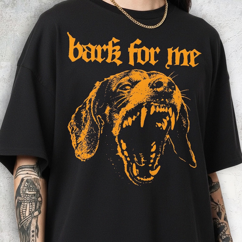 Black vintage t-shirt featuring a high-contrast orange graphic of a snarling Dachshund dog showing teeth, with the text bark for me in gothic font above it, grunge streetwear style.