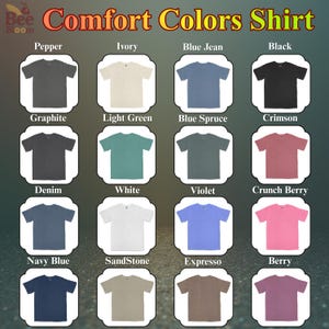 May include: A display of Comfort Colors shirts in various colors, including Graphite, Ivory, Blue Jean, and Black. Each shirt is neatly presented, showcasing the range of available hues. The text "Comfort Colors Shirt" is at the top.