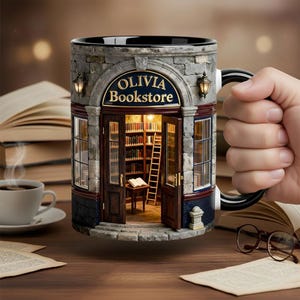 May include: A ceramic mug featuring a three-dimensional design of a stone bookstore facade with the text Olivia Bookstore above the open double doors. The interior view shows bookshelves, a ladder, and a small table with an open book inside.