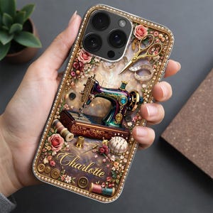 May include: A phone case with a vintage sewing machine design, floral accents, gold scissors, and the name "Charlotte". The case includes spools of thread, buttons, and a pearl border. The design is set against a pearlescent background.