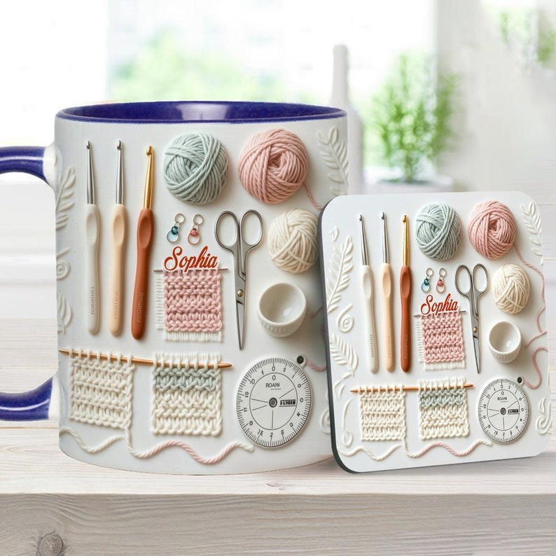 May include: A white ceramic mug and coaster set featuring crochet-themed designs. The mug and coaster have embossed images of crochet hooks, yarn balls, scissors, and a gauge. The mug has a blue rim and handle. The name "Sophia" is also featured.