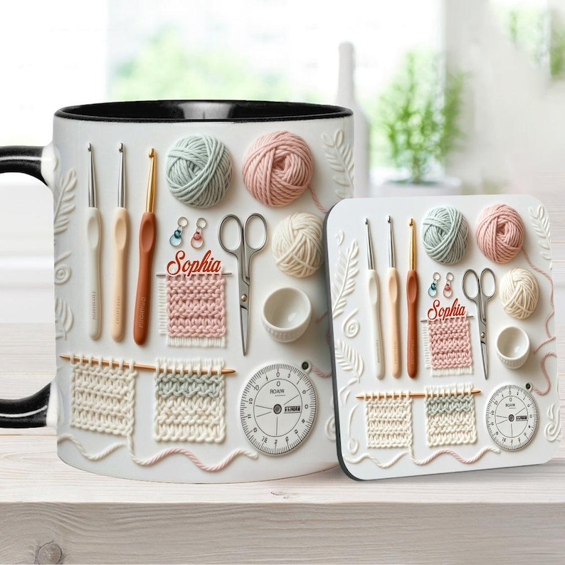 May include: White ceramic mug and coaster set featuring a crochet-themed design. The design includes yarn balls, crochet hooks, scissors, and a gauge. The mug and coaster have the name "Sophia" on them.