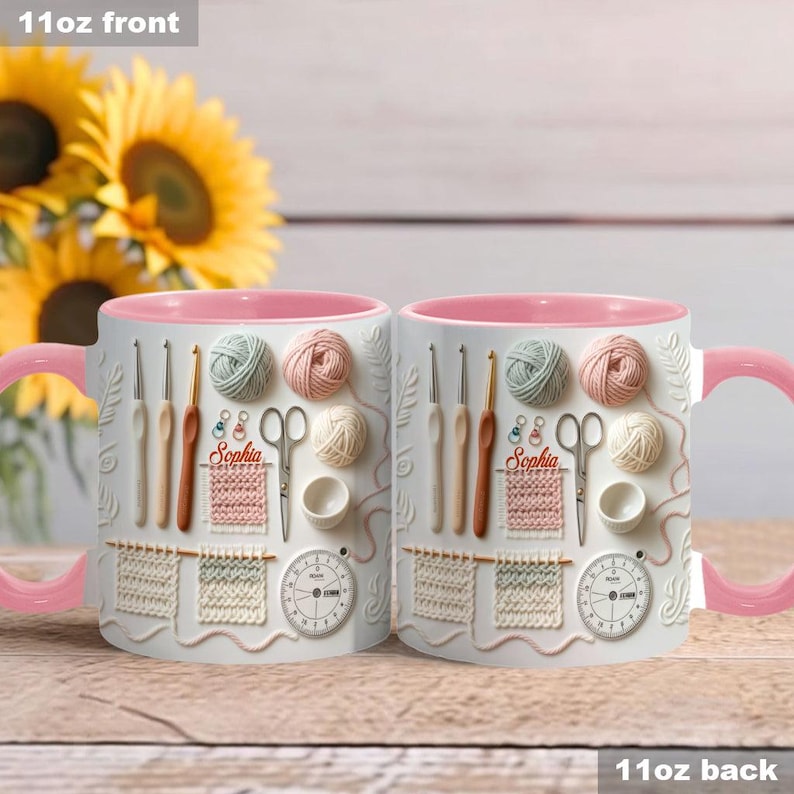 May include: Two white ceramic mugs with pink handles and interiors. The mugs feature a 3D design of knitting and crochet tools, yarn balls, and a clock. The name "Sophia" is printed on the mugs.