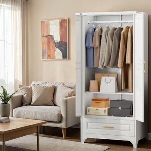 May include: A white wardrobe with two open doors, featuring a hanging rod with various shirts and jackets, a middle shelf holding a white shopping bag and two storage boxes, and a bottom drawer with a gold handle, standing on four legs.