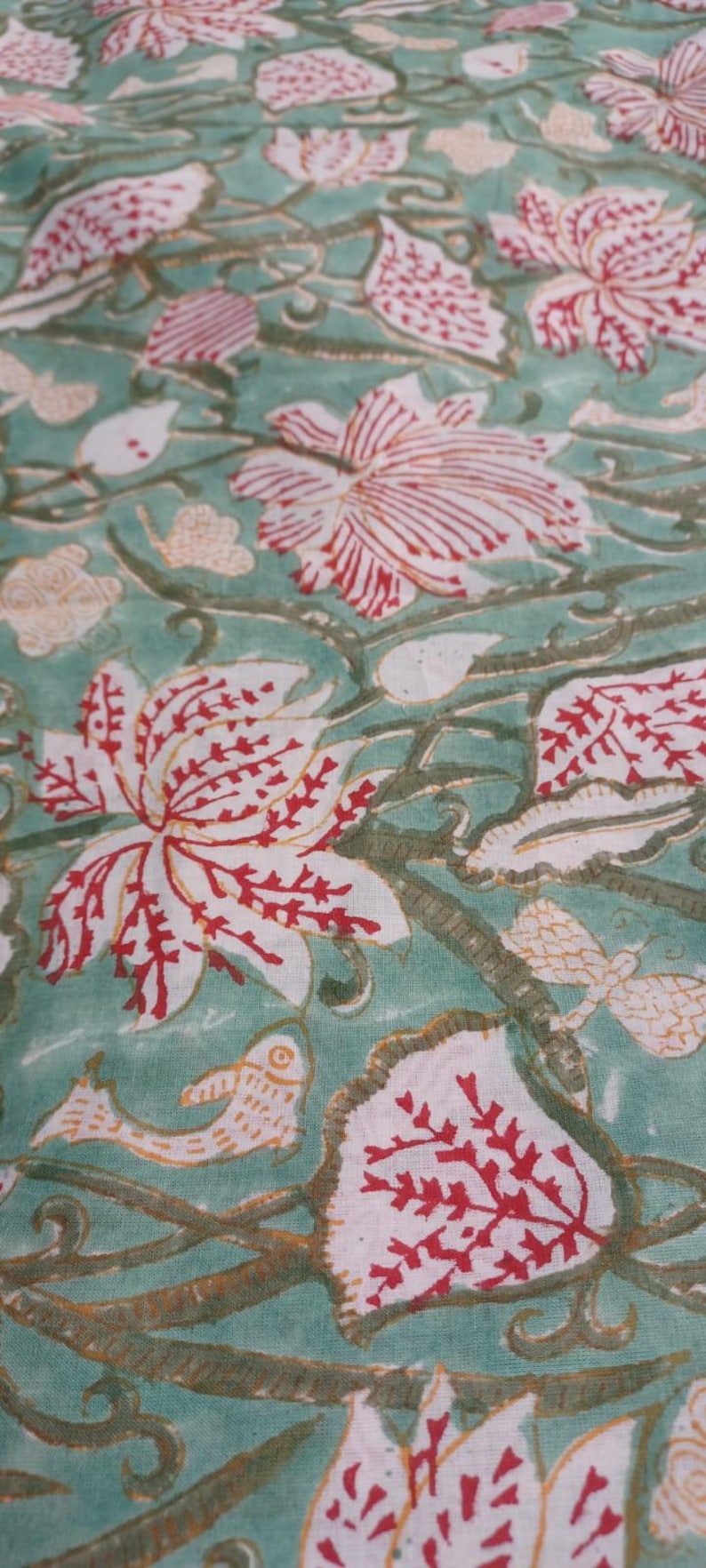 Green floral hand block print cotton fabric
Beautiful Handcrafted Floral Cotton Fabric with Red Lotus Flowers, Botanical Vines and Green Background, Ideal for Boho Home Decor, Cottagecore Sewing, Quilting and Handmade Textile Projects.
Soft Lightweight Hand Block Print Fabric made from Premium Indian Cotton featuring Vintage Red Floral Pattern and Botanical Leaf Design for Dresses, Skirts, Blouses, Quilts and DIY Sewing Projects.