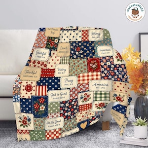 May include: A patchwork throw blanket with a patriotic theme. The blanket features various squares with floral, star, and striped patterns in red, white, and blue. Text includes "America," "Grateful," and Bible verses.