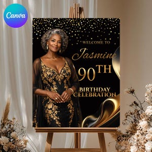May include: A black and gold birthday celebration sign on a wooden easel. The sign features a photo of a woman in a black and gold dress, with the text "Welcome to Jasmine 90th Birthday Celebration". The background is black with gold accents.