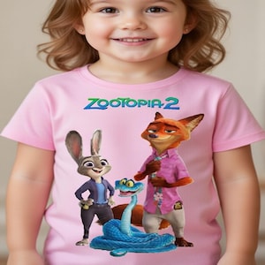 Peut inclure: T-shirt rose avec des personnages du film "Zootopie 2". Le design comprend Judy Hopps, Nick Wilde et un serpent bleu. Le texte "Zootopia 2" est imprim&eacute; en vert et bleu en haut.