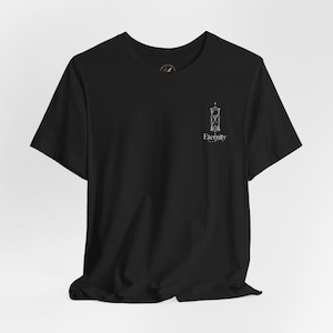 Könnte beinhalten: Ein schwarzes Kurzarm-T-Shirt mit einer kleinen weißen Grafik auf der oberen linken Brust. Die Grafik zeigt ein dünn gezeichnetes Sanduhr-Symbol über dem Wort Eternity, das in einer feinen, eleganten Serifenschrift gedruckt ist.