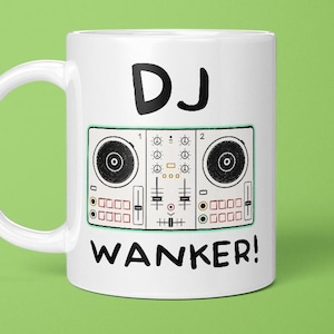 May include: A white ceramic mug featuring a black graphic illustration of a DJ controller console. The text "DJ" is printed in black above the controller, and the word "WANKER!" is printed in black below the controller graphic.