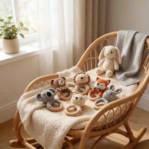 May include: A collection of handmade crochet baby toys, including a bear, lion, fox, koala, and bunny, with wooden ring teethers. The toys are arranged on a wicker rocking chair with a soft blanket, creating a cozy nursery scene.