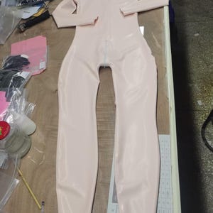 Mono de látex rosa claro hecho a mano, con abertura en el cuello, cremallera en la entrepierna y personalizable.