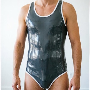 May include: A sleeveless one-piece bodysuit in a glossy dark gray finish, featuring a scoop neckline and armholes trimmed with a contrasting white border. The garment has a fitted silhouette with vertical seam detailing running down the front.