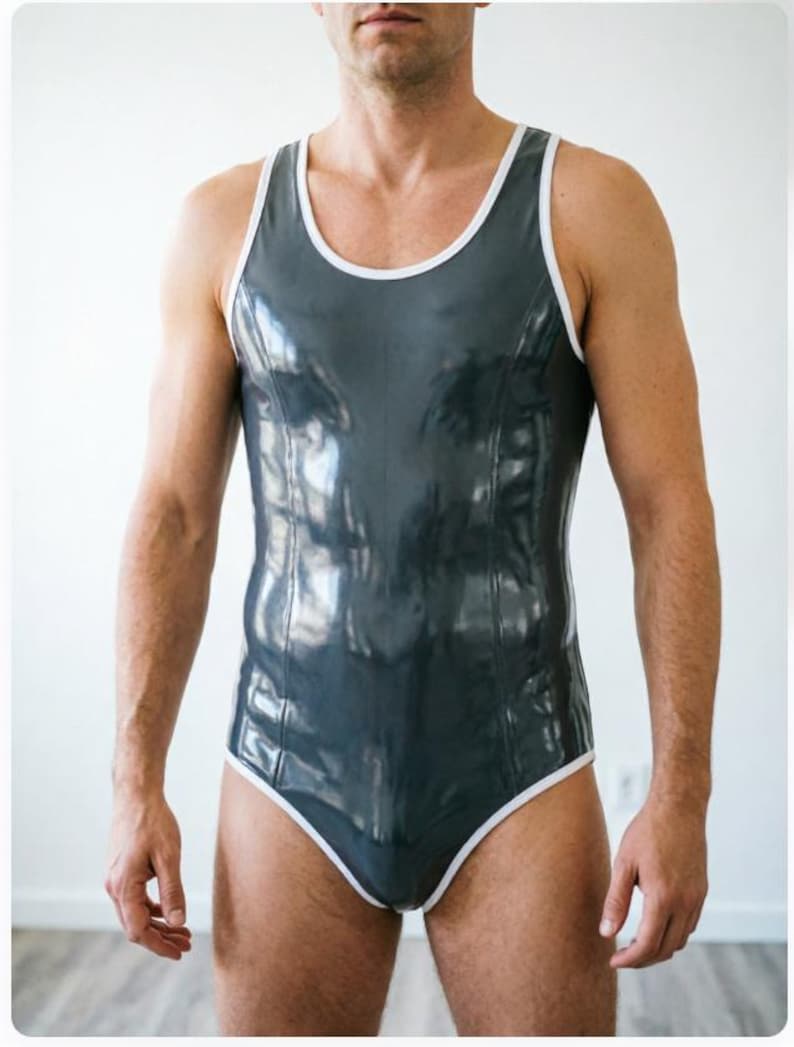 May include: A sleeveless one-piece bodysuit in a glossy dark gray finish, featuring a scoop neckline and armholes trimmed with a contrasting white border. The garment has a fitted silhouette with vertical seam detailing running down the front.