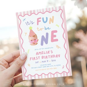May include: A colourful birthday invitation with the words "It's FUN to be ONE". The invitation features a baby wearing heart-shaped sunglasses and a party hat. The invitation includes the name "AMELIA'S FIRST BIRTHDAY".