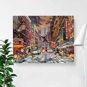 May include: A canvas print depicting a cityscape with superheroes in action. The artwork features a vibrant street scene with buildings, cars, and figures in superhero costumes. The words "Now Playing" are visible on a theater marquee.