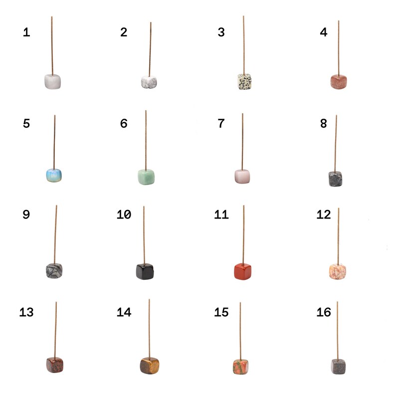 Puede incluir: Una colecci&oacute;n de diecis&eacute;is porta inciensos, cada uno con una base cuadrada de diferente color. Las bases var&iacute;an en color, incluyendo blanco, gris, rosa, azul, verde y marr&oacute;n. Cada soporte tiene un palo delgado y marr&oacute;n que se extiende hacia arriba.