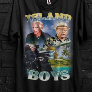 May include: Black t-shirt featuring a graphic with three men, the text "ISLAND BOYS" and a tropical scene. The shirt also has the text "BUY 3 FREE" and "CODE: 3SHIP". The brand logo "SEVENTHREE SEVEN" is at the top.