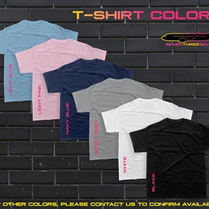 Puede incluir: Una exhibici&oacute;n de seis camisetas en varios colores: azul claro, rosa claro, azul marino, gris deportivo, blanco y negro. Cada camiseta tiene el nombre del color impreso verticalmente en rosa. El texto "T-SHIRT COLORS" est&aacute; en la parte superior, con un avi&oacute;n y "SEVENTHREESEVEN".