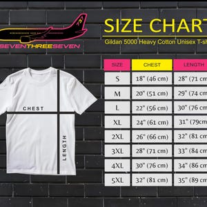 Puede incluir: Una camiseta unisex Gildan 5000 Heavy Cotton blanca con una tabla de tallas. La tabla enumera las medidas de pecho y largo en cm para las tallas S a 5XL. La camiseta tiene el texto "SEVENTHREESEVEN" y un gr&aacute;fico de avi&oacute;n.