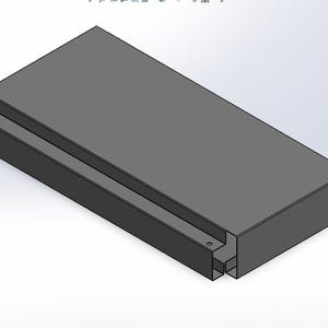 May include: A rectangular, gray, 3D-modeled object with a recessed channel running along one side. The object has a solid, block-like appearance with a consistent color and texture throughout. The design is simple and geometric.