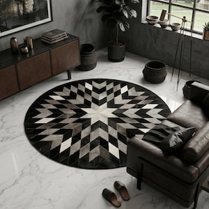 May include: A modern living room featuring a large, round rug with a geometric starburst pattern in shades of black, gray, and white. The room includes a brown leather sofa, a dark wood cabinet, and a large window.