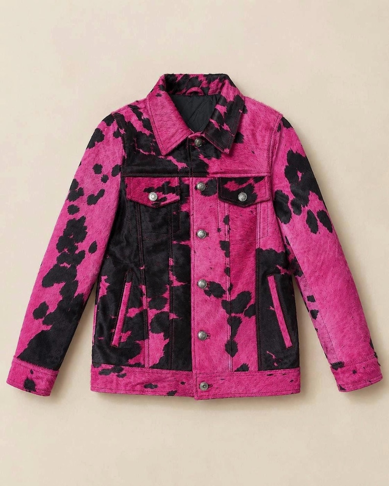 May include: A long-sleeved jacket featuring a vibrant hot pink and black cow print pattern. The garment includes a classic collar, a front button-down closure with metallic buttons, two chest pockets with buttoned flaps, and two vertical side pockets.