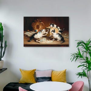 May include: A framed print shows four kittens at play in a vintage style. The black and white kittens are interacting with a box, cards, and a ball. The artwork has a warm colour palette with a detailed, classic aesthetic.