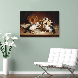May include: A framed print showing four kittens at play in a vintage style. The black and white kittens are gathered around a table with playing cards and a box. A colourful ball and ornate frame are also visible.