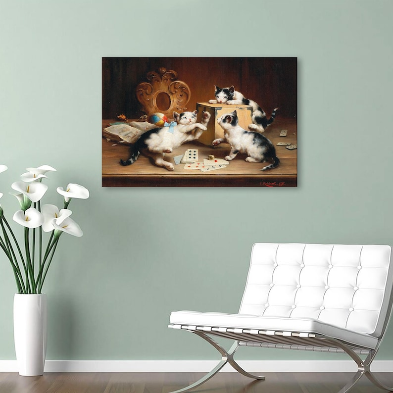 May include: A framed print showing four kittens at play in a vintage style. The black and white kittens are gathered around a table with playing cards and a box. A colourful ball and ornate frame are also visible.
