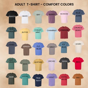May include: A grid of thirty short-sleeved crew neck t-shirts in various colours, labelled with text including Black, White, Bay, Berry, Blossom, Blue Jean, Blue Spruce, Butter, Chalky Mint, Chambray, Crimson, Crunch Berry, Denim, Espresso, Flo Blue, Gray, Ice Blue, Ivory, Light Green, Moss, Mustard, Orchid, Pepper, Red, Sage, Seafoam, True Navy, Violet, Watermelon, and Yam. The header reads ADULT T-SHIRT - COMFORT COLORS.