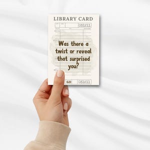 May include: A library card with the text "Was there a twist or reveal that surprised you?" in a vintage style. The card has a cream background with brown text and lines. The card is held by a hand.