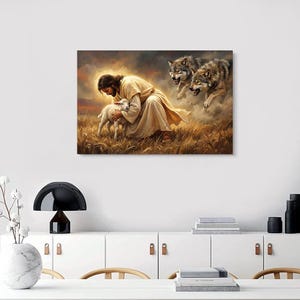 May include: A canvas print depicting a religious scene. A figure in a cream-colored robe cradles a lamb in a field of tall grass. Two wolves are in the background, with a cloudy sky above.