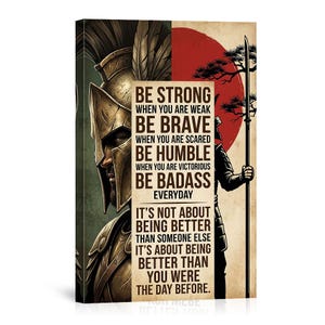 May include: Canvas art print featuring a warrior in a golden helmet and a spear-wielding figure against a red sun backdrop. The artwork includes motivational text: "Be Strong," "Be Brave," "Be Humble," and "Be Badass." The overall theme is one of strength and self-improvement.