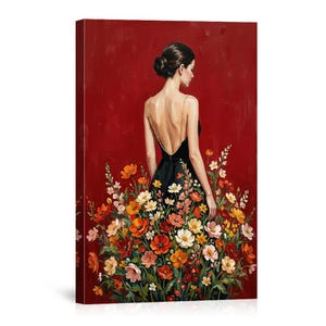May include: A canvas print of a woman in a black dress with a floral skirt, standing in front of a red background. The dress has gold chain straps. The flowers are in shades of red, orange, yellow, and pink.