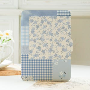 Peut inclure: Un étui rectangulaire avec un motif patchwork. L'étui présente divers motifs bleus, notamment des motifs floraux, vichy et des sections unies. La palette de couleurs est principalement bleu clair et crème, créant une esthétique vintage. L'étui a un bord incurvé et une petite languette.
