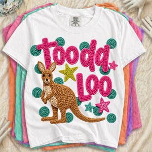 May include: White t-shirt with a crochet kangaroo and the words "Toooda Loo" in pink. The design includes green polka dots and yellow and pink stars. The shirt is a Comfort Colors brand.