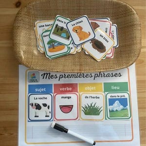 Peut inclure: Un ensemble d'apprentissage de la langue française avec des cartes et une feuille de travail. Les cartes présentent des illustrations et des mots. La feuille de travail a des sections pour le sujet, le verbe, l'objet et le lieu. Un marqueur effaçable à sec est inclus.