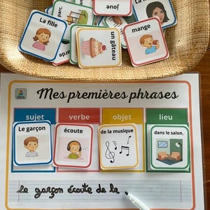 Peut inclure: Matériel pédagogique pour l'apprentissage du français. L'image présente des cartes illustrées avec des mots comme "La fille" et "un gâteau", ainsi qu'une feuille de travail avec des sections pour sujet, verbe, objet et lieu. La phrase "Le garçon écoute de la..." est écrite.