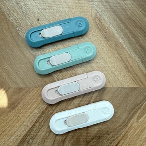 May include: Four small, colorful box cutters in shades of blue, green, pink, and white. Each cutter has a sliding blade mechanism and the number "12" printed on the end. The text "MADE IN CHINA" is printed on the pink and white cutters.