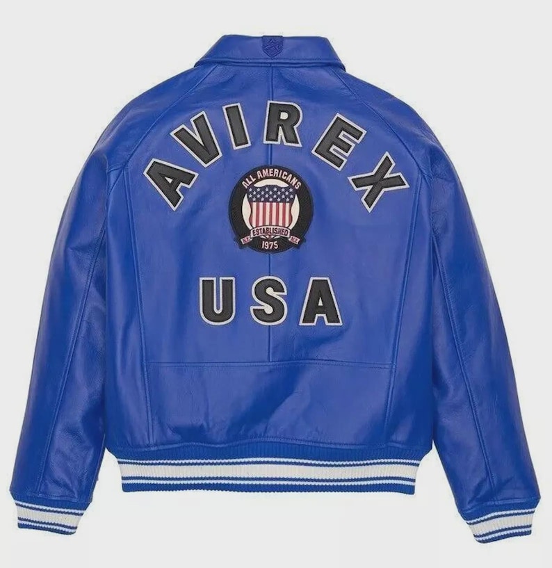 May include: A vibrant blue leather jacket with the word "AVIREX" arched across the shoulders. Below the word "AVIREX" is a circular patch with the words "ALL AMERICANS ESTABLISHED 1975" and a USA flag design. The word "USA" is printed below the patch.