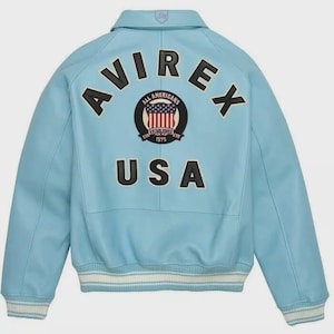 May include: Light blue leather jacket with the word "AVIREX" across the back in black letters. Below the word "AVIREX" is a circular patch with the words "ALL AMERICANS" and "ESTABLISHED 1975". Below the patch is the word "USA".